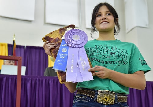 A girl holding her prize ribbons