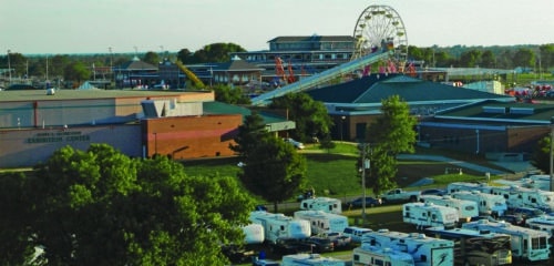 Overview of the Missouri State Fair exhibitor campground and Mathewson Exhibition Center with carnival in the background