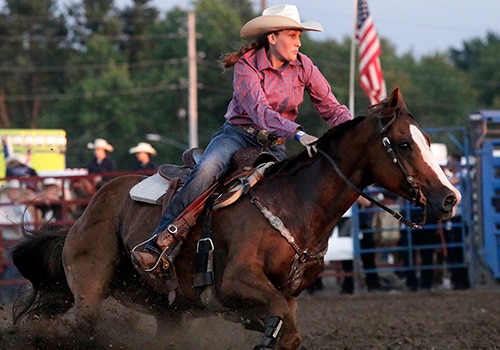 Woman riding horse in rodeo
