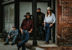 The Clay Clear band standing outside a brick building