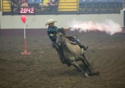Cowboy Mounted Shooter on horse shooting at target during the Cowboy Mounted Shooting contest