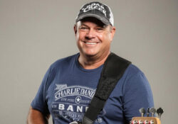 Darryl Grandfield posing with his guitar