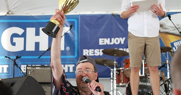 A man holding up the Homegrown Singer trophy