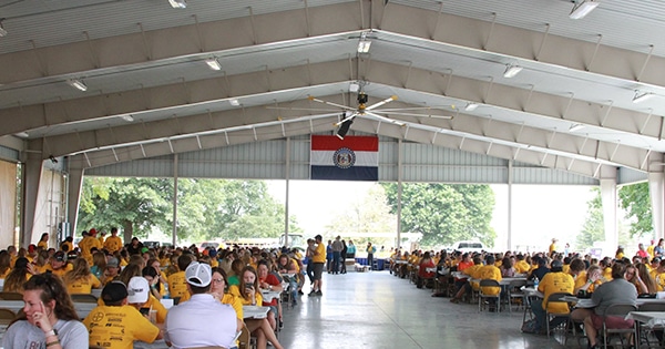 A large group of people seated at tables under the Director's Pavilion