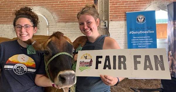 Two girls with a 'Fair Fan' sign