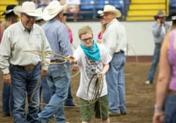 A boy throwing a rope in the arena