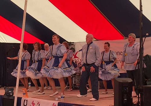 The Mule Kicker Cloggers Performing on a covered stage