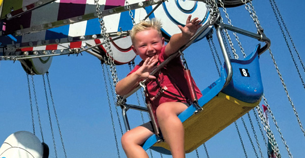 A little boy smiling on a carnival ride